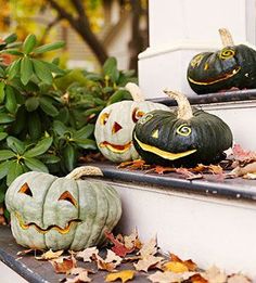 pumpkins with faces carved into them sitting on the steps