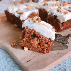 a piece of carrot cake on a wooden cutting board