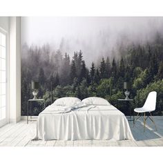 a bedroom with a forest mural on the wall and a bed in the foreground