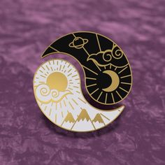 a black and white pin with the moon and sun on it's side, against a purple background