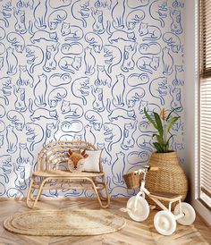 a child's room with blue and white wallpaper, a wooden rocking chair, and a basket on the floor