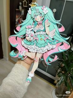 a person holding up a paper doll in their hand