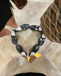 three people standing in a circle with their shoes on