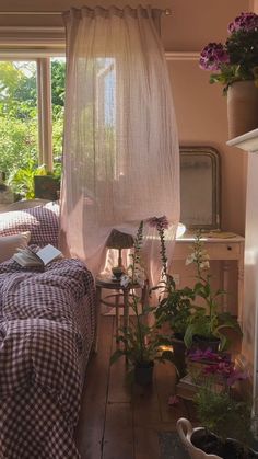 a room with two beds and plants in it