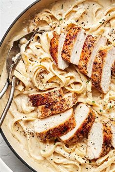 a pan filled with chicken and noodles on top of a table