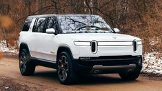 a white suv driving down a dirt road