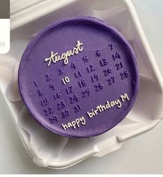 a purple birthday cake in a white container