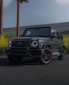 a black mercedes g - class parked in front of a building