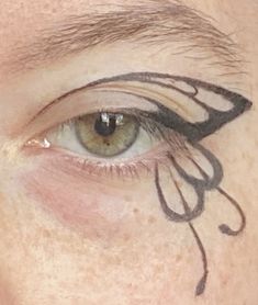 Black winged eyeliner that resembles a butterfly wing Butterfly Wings Eyeliner, Makeup With Graphic Eyeliner, Butterfly Liner Makeup, White Butterfly Eyeliner, Butterfly Eyeliner Hooded Eyes, Easy Butterfly Eyeliner, Butterfly Wing Makeup, Butterfly Graphic Liner, Graffiti Eyeliner