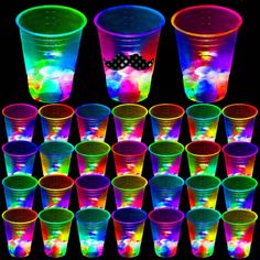 many different colored plastic cups are arranged in the shape of rainbows and dots on black background