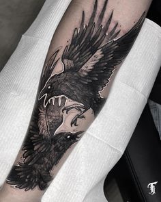 a black and white tattoo on the arm of a man with an eagle in it's beak