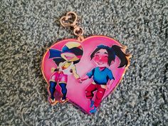 a heart shaped keychain with two cartoon characters on it