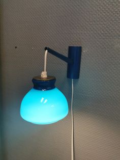 a blue light that is on the wall next to a phone charger and plugged in