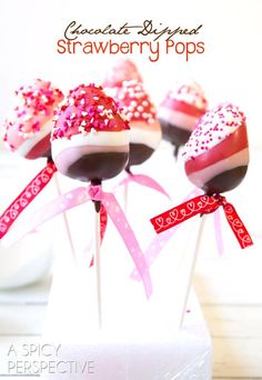 chocolate covered lollipops with pink sprinkles and hearts on them