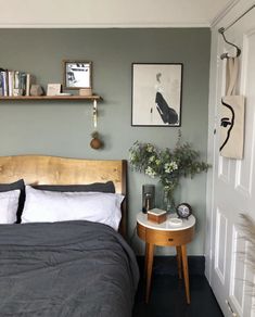 a bed sitting in a bedroom next to a wall with pictures hanging on the walls