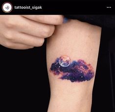 a person with a tattoo on their arm that has the sky and stars painted on it