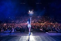 a woman walking down a runway in front of a crowd