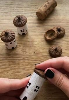 someone is holding a cork with some sort of house on it and there are other things in the background