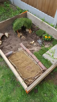 an open wooden box with grass growing out of it in the middle of a yard