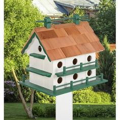 a white bird house sitting on top of a wooden pole