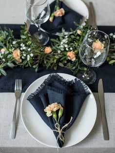 a place setting with napkins, flowers and silverware