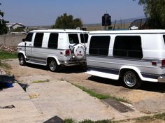 two white vans parked next to each other