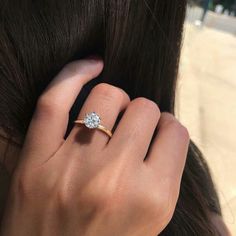 a woman's hand with a diamond ring on her finger