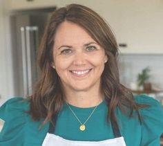 a woman wearing an apron and smiling at the camera