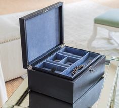 an open jewelry box sitting on top of a glass table