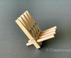 a small wooden chair with several pairs of scissors on it's back and two forks sticking out of the top