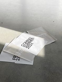 three pieces of white paper sitting on top of a cement floor next to each other