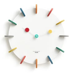 a clock with different colored sticks sticking out of it's face and numbers on the face