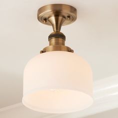 a close up of a light fixture with a white glass shade on the top and bottom