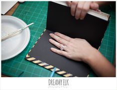 a woman's hand is on top of a book with a pen in it