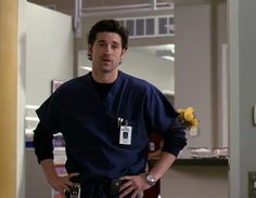 a man in scrubs standing with his hands on his hips