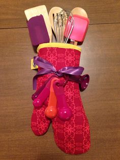 an oven mitt with utensils and spoons in it on a table