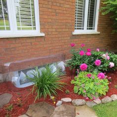 a flower bed in front of a brick house