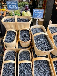 baskets of blueberries are stacked on top of each other in front of produce stands