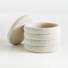 a stack of white round bath sponges sitting on top of each other in front of a white background