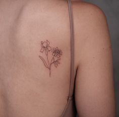 a woman's back with a flower tattoo on it