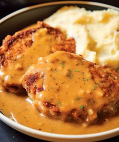 two meat patties covered in gravy and mashed potatoes