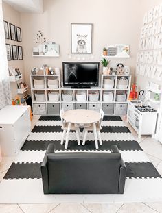 a living room with black and white flooring and furniture in it's center