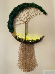 a wall hanging with a tree made out of branches and lights in the shape of a circle