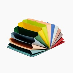 several different colored folders stacked on top of each other in various shapes and sizes