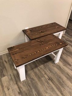 two wooden benches sitting next to each other on top of a hard wood floored floor