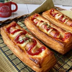 some very tasty looking pastries on a cooling rack next to a red cup