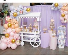 a dessert cart with balloons and cake on the table in front of purple backdrops