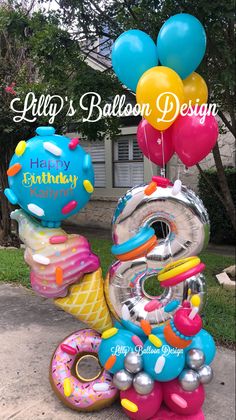 an ice cream cone, doughnuts and balloons are displayed in front of a house