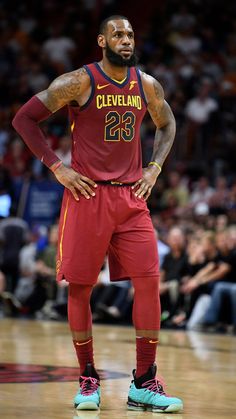 a basketball player standing on the court with his hands on his hips