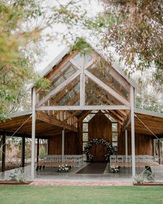 an outdoor wedding venue with white chairs and greenery